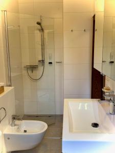 a white bathroom with a sink and a shower at Ferienhaus Leitner in Kitzeck im Sausal +15 photos