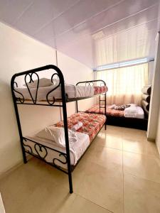 two bunk beds in a room with a window at Acogedor apartamento en Pereira in Pereira