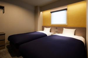 two beds in a room with a window at Minn Gion Sanjo in Kyoto +19 photos