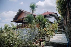 a house with palm trees in front of it at RedDoorz at Villa Bukit Senyum Lombok in Kuripan