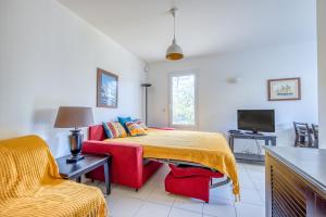 un soggiorno con letto e divano rosso di Studio avec piscine - proche plage a Soulac-sur-Mer