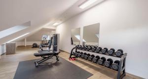 a gym with treadmills and exercise bikes in a room at Aiden by Best Western Biberach in Biberach an der Riß