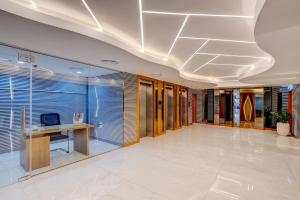 an office lobby with a desk and a computer on it at Vendome Plaza Hotel in Dubai