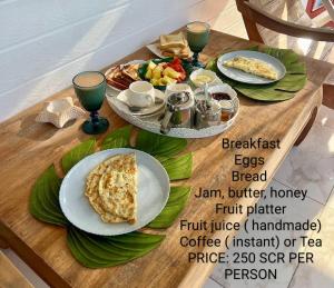 a table with two plates of food on it at Lucy's guesthouse in La Digue