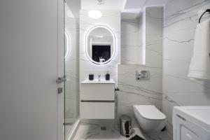 VoluntariにあるIvory Concept Studio 27のトイレと鏡のある白いバスルーム +26枚の写真