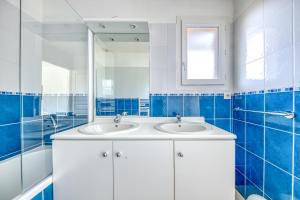Un baño con dos lavabos y un espejo. en 3 pièces - Piscine - Proche plage, en Soulac-sur-Mer 16 fotos más