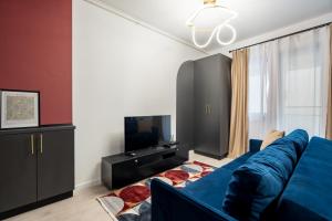 VoluntariにあるIvory Concept Studio 27の青いソファとテレビのあるリビングルーム