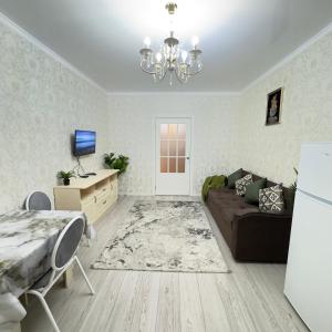 a living room with a couch and a table at Urban Oasis 216 in Almaty +6 photos