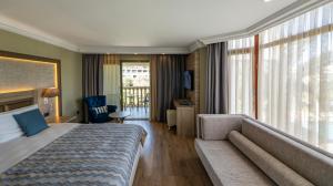 a hotel room with a bed and a couch at Samara Hotel Bodrum Ultra All Inclusive in Torba