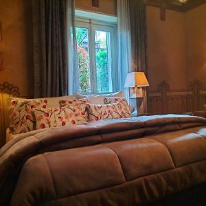 a bedroom with a large bed with a window at Villa Costanza Appartamento con giardino in Magreglio