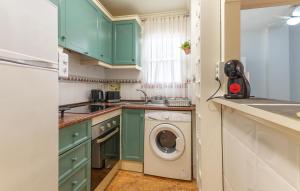 a kitchen with green cabinets and a washing machine at Gorgeous Apartment In Torrevieja in Torrevieja
