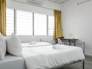 2 Betten in einem Zimmer mit Fenstern in der Unterkunft Lodge 22, 5 min walk to Adventist & Pulau Tikus Market in George Town