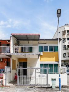 ein Gebäude mit einem weißen Zaun davor in der Unterkunft Lodge 22, 5 min walk to Adventist & Pulau Tikus Market in George Town