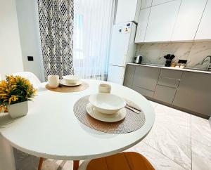 a white table in a kitchen with two dishes on it at Уютная квартира на Левом берегу, ТРЦ Хан Шатыр in Astana