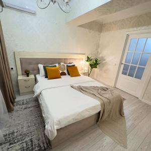 a bedroom with a large bed and a window at Your Home Away from Home 213 in Almaty