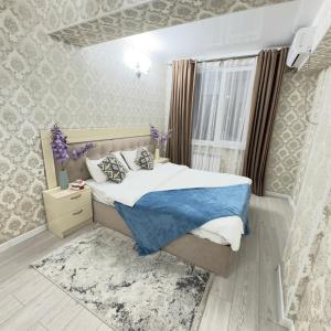 a small bedroom with a bed and a window at Your Home Away from Home 213 in Almaty