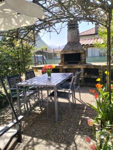 a table and chairs in a yard with a fireplace at La Casa del Lago in Porlezza