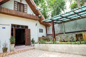 an external view of a house with a wooden door at La Cabina - Charming quiet house - Free Motobike in Luang Prabang