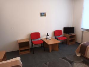 a room with three chairs and a table and a tv at Leon in Biała Podlaska +28 photos