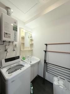 a bathroom with a sink and a washing machine at Sun Court Heiwa-dori 801 in Tsukisappu
