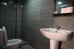 un bagno con lavandino, water e specchio di FOX Orbi Resort Hotel a Itʼkhvisi Altre 36 foto