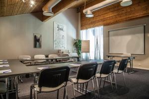 a classroom with tables and chairs and a projection screen at Sirdal Høyfjellshotell in Fidjeland