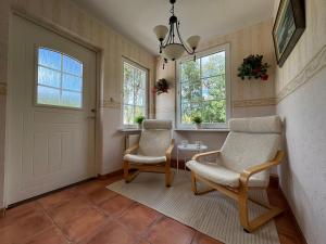 a hallway with two chairs and a door at Large Swedish Countryside Villa with Garden & Nature Views In Kalmar in Abbetorp