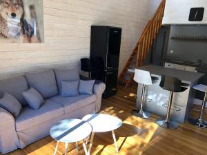 ein Wohnzimmer mit einem blauen Sofa und einem Klavier in der Unterkunft Gite en plein coeur de la Lozère Chalet 2 in Banassac + 5 Fotos