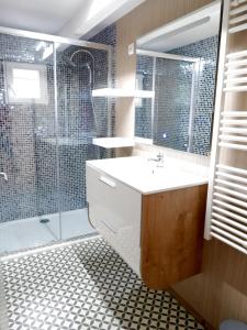 ein Badezimmer mit einem Waschbecken und einer Dusche mit einer Glastür in der Unterkunft Gite en plein coeur de la Lozère Chalet 2 in Banassac