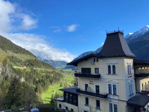 a large white building with a black roof at Das Schider - Boutique Apart-Hotel in Bad Gastein