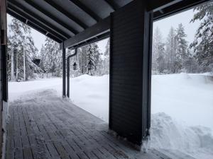 un porche cubierto con nieve en el suelo en Q-maja, en Syöte