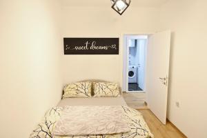 a bedroom with a bed and a sign on the wall at Apartman KALINA in Bileća