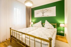ein Schlafzimmer mit einem Bett mit einer grünen Wand in der Unterkunft Velden - Villa right in the center with private parking in Velden am Wörthersee