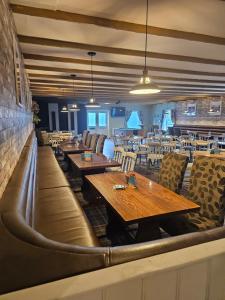 a dining room with wooden tables and chairs at PB6 in Bettws-Evan