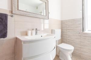 a white bathroom with a toilet and a sink at Naša kuća in Vela Luka +33 photos