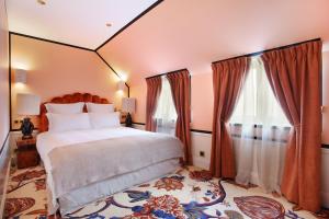 a bedroom with a large bed and two windows at Makom Ferdinand Duval in Paris
