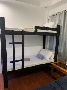 a black bunk bed in a room with a table at Recuerdo Transient House By LA MAR Hospitality in El Nido