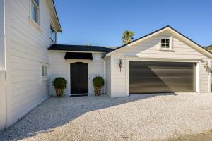 a white house with a garage at Nile Street Studio in Nelson