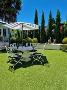 a table and chairs under an umbrella in a yard at Nile Street Studio in Nelson