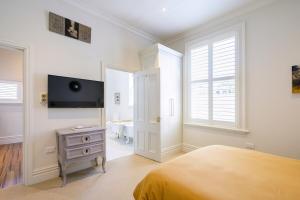 a bedroom with a bed and a tv on the wall at Nile Street Studio in Nelson