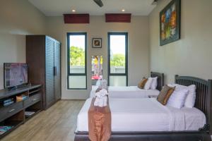 a bedroom with two beds with a tv at Narintara Private Villas - Hotel style service with Free Tuk Tuk to the beach in Ao Nang Beach +38 photos