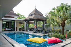 a swimming pool with two yellow and red pillows on it at Narintara Private Villas - Hotel style service with Free Tuk Tuk to the beach in Ao Nang Beach