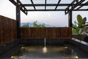 a patio with a water fountain and a wooden fence at 青城山泉青小院温泉中式民宿 in Taiping