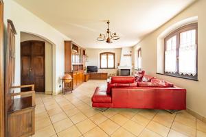 a living room with a red couch and a kitchen at Tenuta Oltrevento in Dogliani