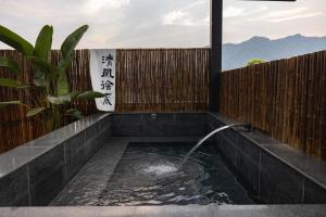 a pool of water in a courtyard with a fence at 青城山泉青小院温泉中式民宿 in Taiping