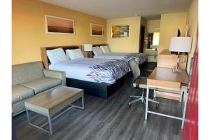 Una habitación de hotel con dos camas, un sofá y un escritorio. en Budget Inn By Belvilla St George I-95, en Saint George 18 fotos más