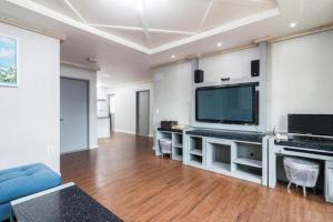 a living room with a large television and a blue couch at Show Hotel Haeundae in Busan