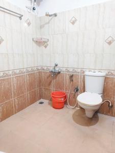 a bathroom with a toilet and a bucket at White House in Hosūr +20 photos