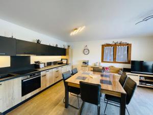 a kitchen with a table and chairs in a room at Le RandAulps in Saint-Jean-d'Aulps