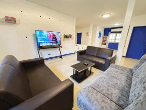 a living room with two couches and a flat screen tv at 曼谷市中心大空间6卧室花园泳池别墅 in Bangkok